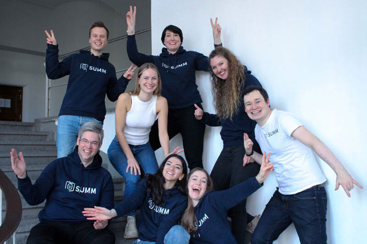 This is a picture of the SUMM team. Eight people are laughing for the camera. There are three men and five women.