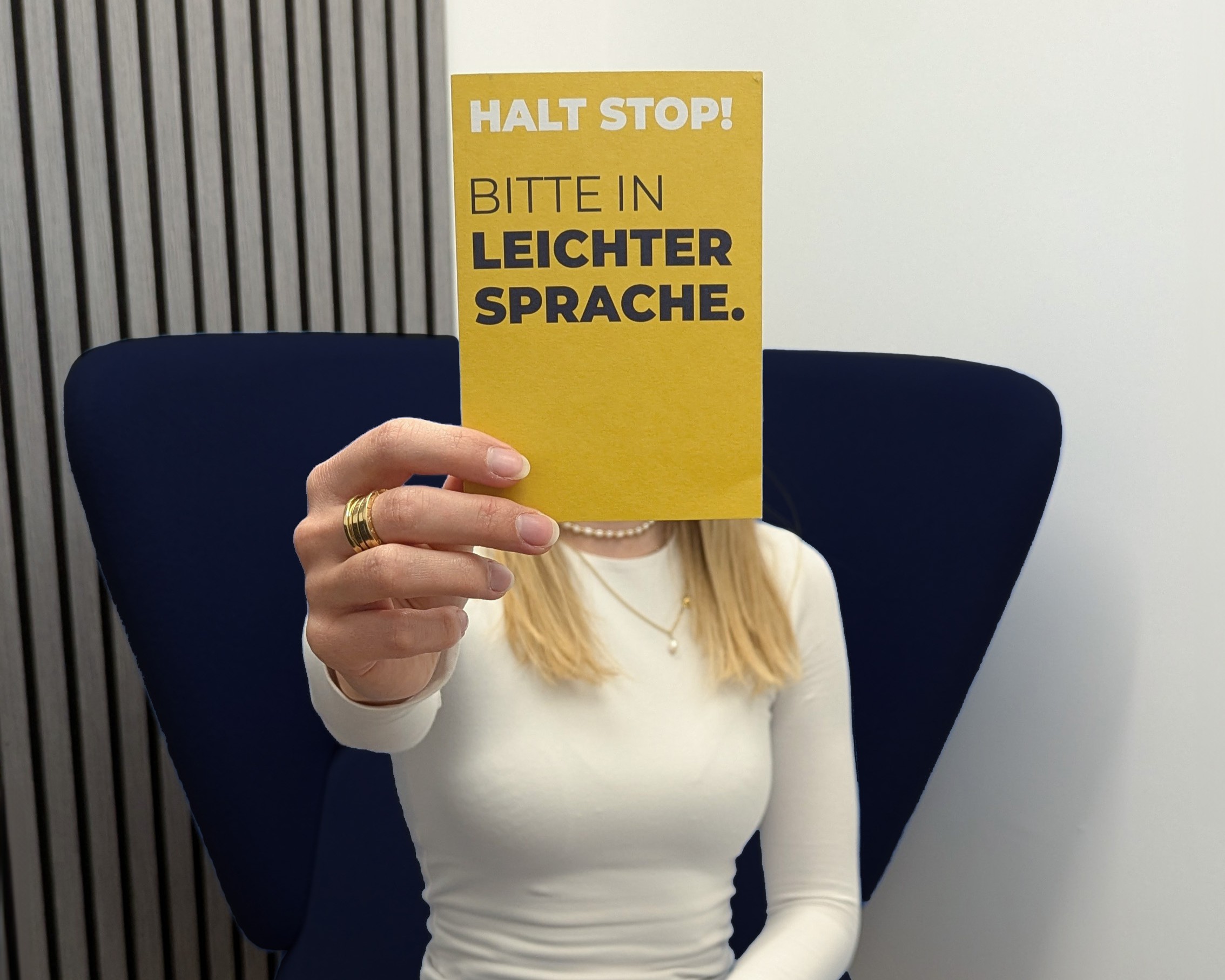Gerichtsverfahren Ein hölzerner Richterhammer liegt auf einem Tisch im Vordergrund. Im Hintergrund sitzen unscharf zwei Personen in formeller Kleidung, die über Dokumente sprechen oder unterzeichnen – eine Szene, die auf juristische Beratung, ein Gerichtsverfahren oder eine rechtliche Besprechung hinweist.